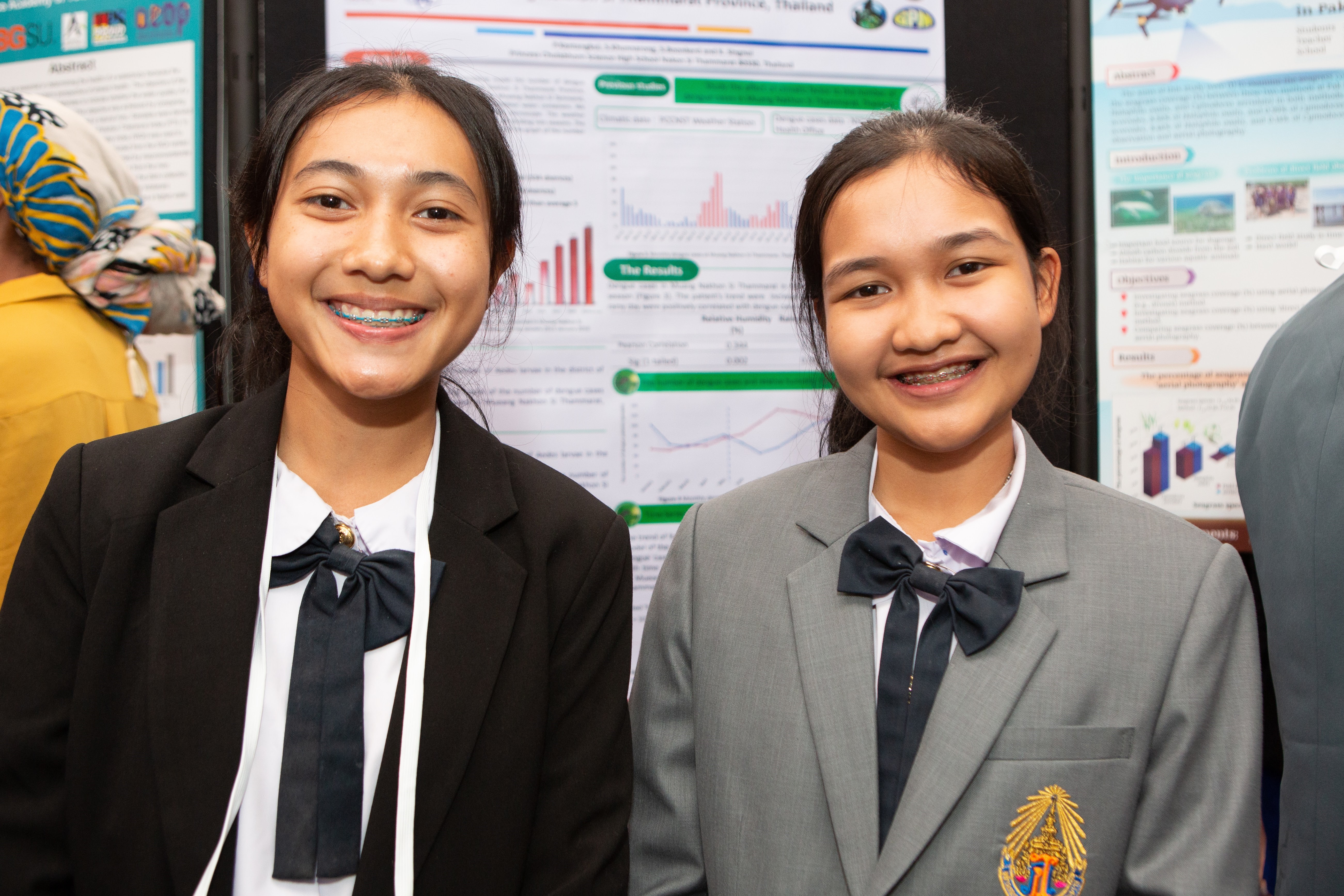 Two students stand next to each other while smiling.